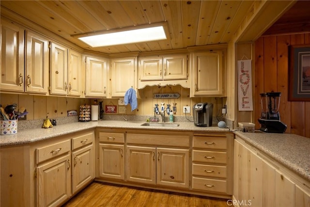 kitchen with light wood-type flooring, wooden walls, light brown cabinetry, and wood ceiling