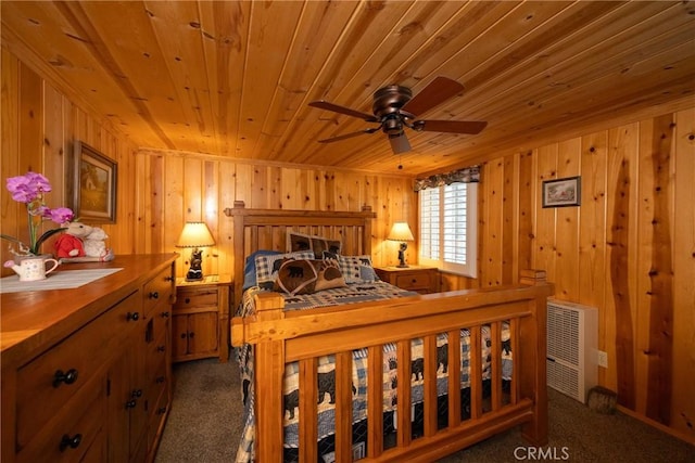 bedroom featuring dark carpet, wooden walls, and wooden ceiling