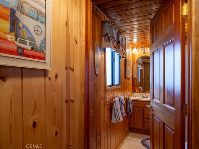 bathroom with vanity, wooden ceiling, and wooden walls