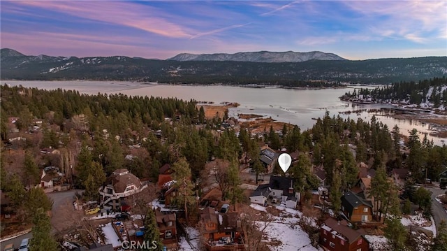 aerial view at dusk featuring a water and mountain view