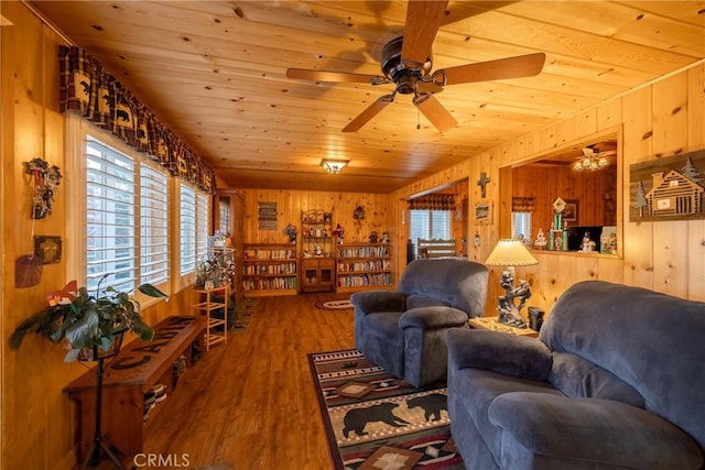 living room featuring wood ceiling, ceiling fan, wood-type flooring, and wooden walls