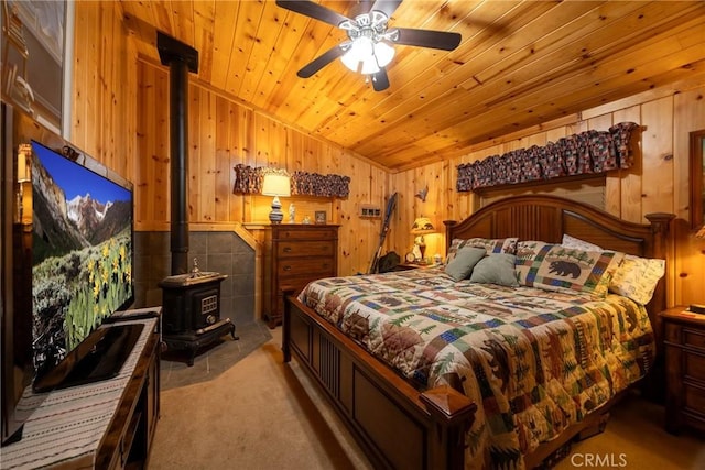 bedroom featuring a wood stove, wooden ceiling, vaulted ceiling, light colored carpet, and wood walls