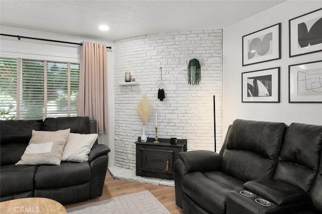 living room with brick wall and light wood-type flooring