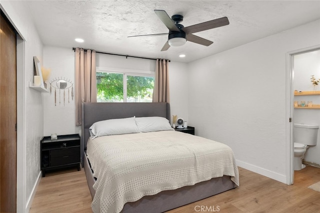 bedroom featuring ceiling fan, light hardwood / wood-style flooring, a textured ceiling, and ensuite bathroom