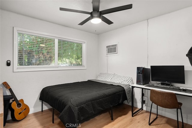 bedroom featuring ceiling fan, a wall unit AC, and light hardwood / wood-style floors