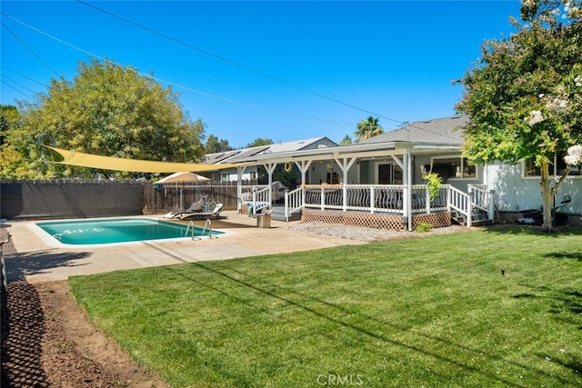 view of pool with a deck, a patio area, and a lawn