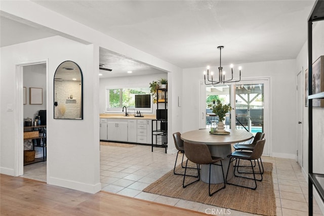 tiled dining space with sink and a notable chandelier