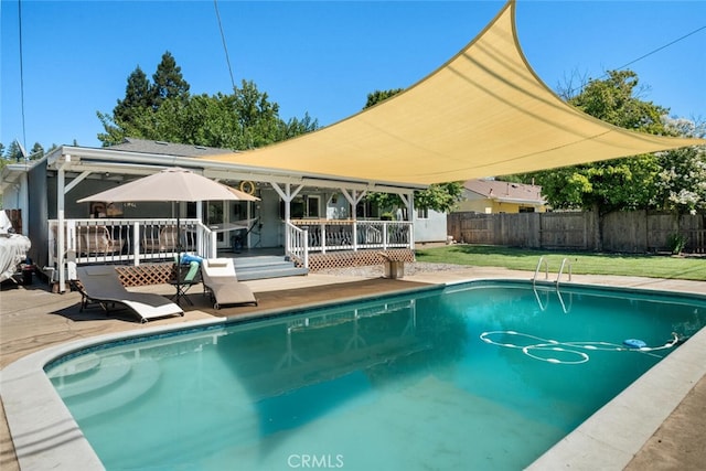 view of swimming pool with a wooden deck and a lawn