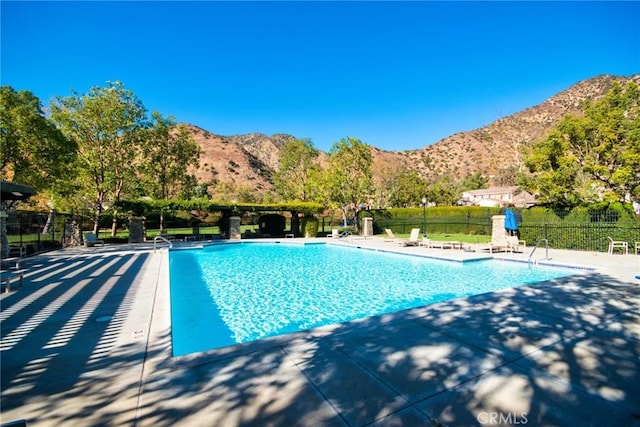 view of swimming pool with a mountain view and a patio area