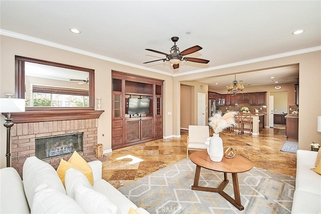 living room featuring crown molding, ceiling fan with notable chandelier, and a brick fireplace