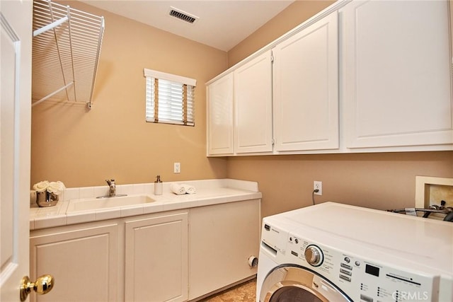 washroom with sink, washer / dryer, and cabinets