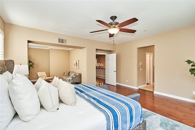 bedroom featuring dark wood-type flooring and ceiling fan with notable chandelier