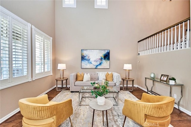 living room with a towering ceiling and hardwood / wood-style flooring