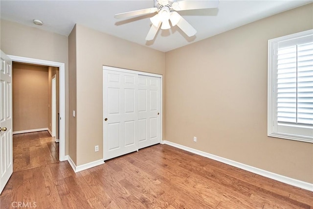 unfurnished bedroom with light hardwood / wood-style flooring, a closet, and ceiling fan