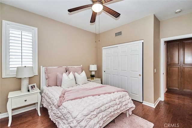 bedroom with ceiling fan, dark hardwood / wood-style flooring, and a closet