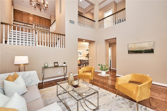 living room with beam ceiling, hardwood / wood-style floors, and a chandelier