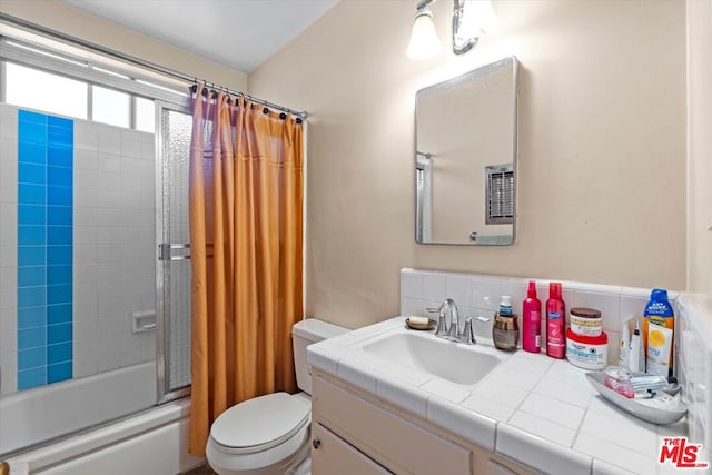 full bathroom with vanity, tasteful backsplash, toilet, and tiled shower / bath