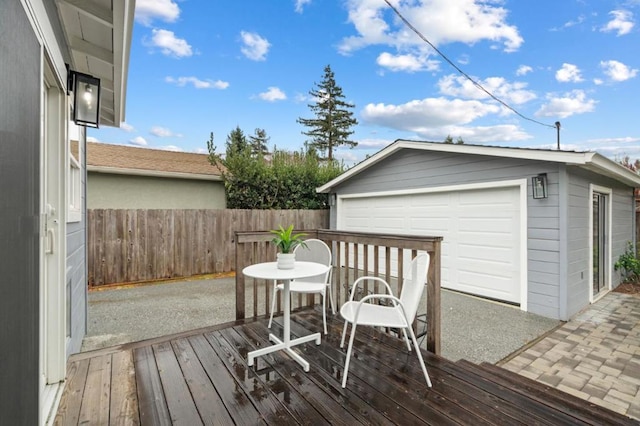 wooden terrace featuring a garage and an outdoor structure