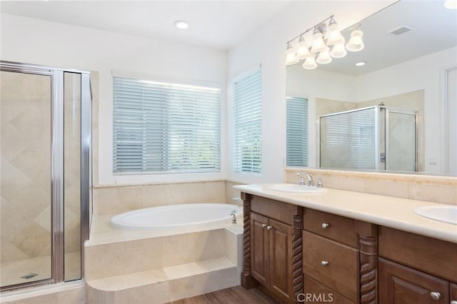 full bathroom featuring double vanity, a stall shower, visible vents, a sink, and a bath