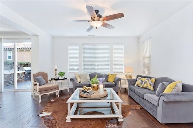 living room featuring dark wood-type flooring and ceiling fan