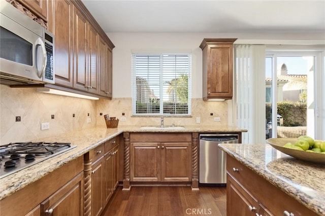 kitchen featuring light stone countertops, appliances with stainless steel finishes, sink, and dark hardwood / wood-style floors