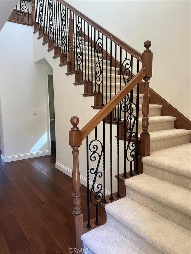 stairs featuring wood-type flooring and baseboards