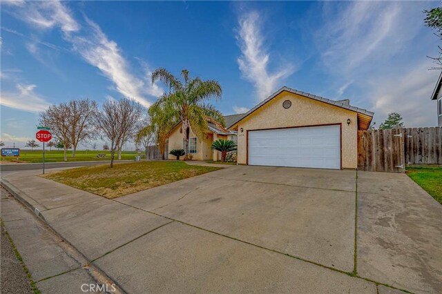 ranch-style home featuring a garage and a front lawn