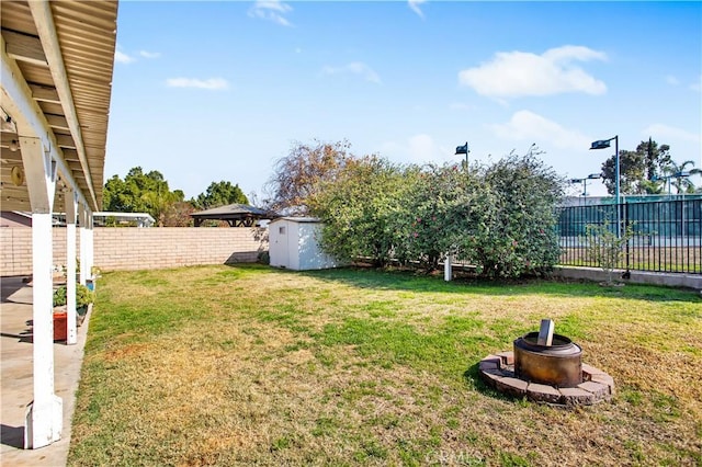 view of yard with a storage shed and a fire pit