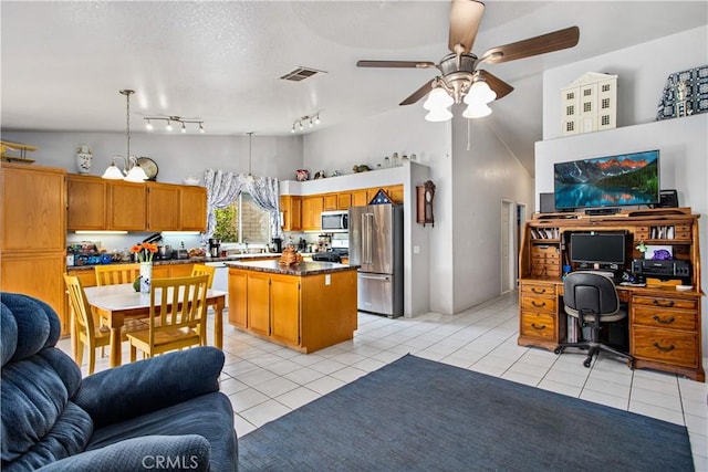 kitchen featuring a kitchen island, appliances with stainless steel finishes, ceiling fan with notable chandelier, decorative light fixtures, and light tile patterned floors