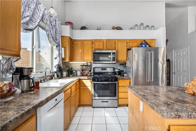 kitchen featuring light tile patterned flooring, a towering ceiling, appliances with stainless steel finishes, and sink