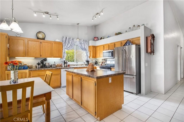 kitchen featuring pendant lighting, sink, appliances with stainless steel finishes, a center island, and a notable chandelier