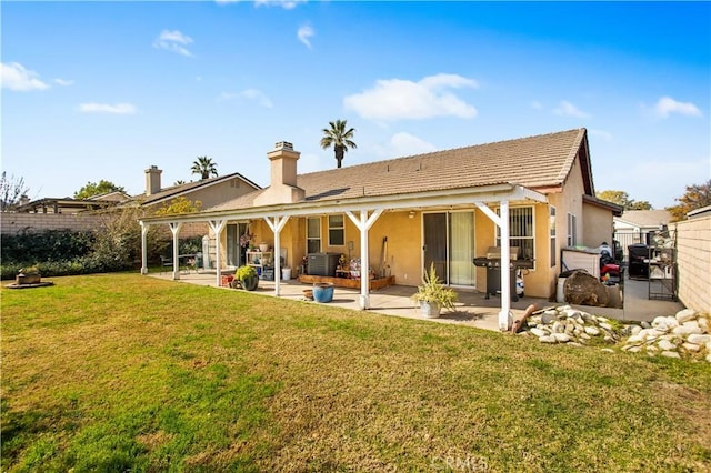 rear view of house featuring a yard, central AC unit, and a patio