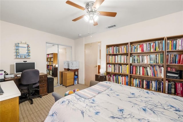 carpeted bedroom featuring ceiling fan and a closet