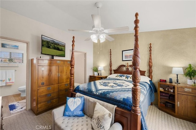 carpeted bedroom with ceiling fan and ensuite bathroom