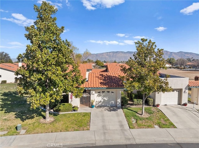 view of front facade with a mountain view, a garage, and a front lawn