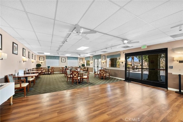 dining area with hardwood / wood-style flooring, a paneled ceiling, and ceiling fan