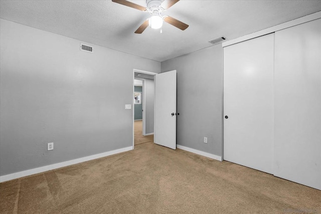 carpeted empty room featuring a textured ceiling and ceiling fan