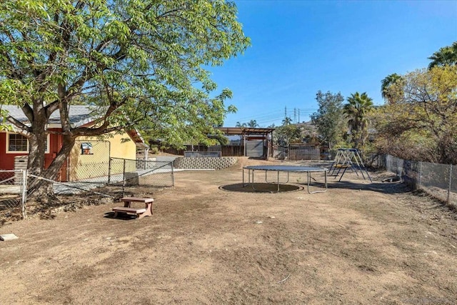 view of yard featuring a playground and a trampoline