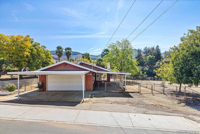 view of front facade with a garage, a mountain view, and a rural view