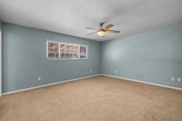 carpeted empty room with ceiling fan and a textured ceiling