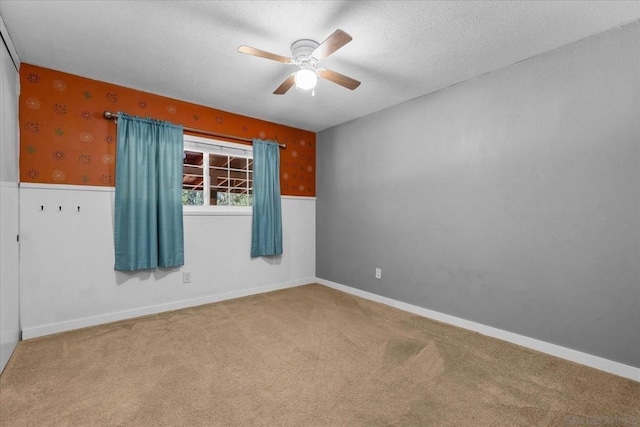 empty room with ceiling fan, carpet, and a textured ceiling