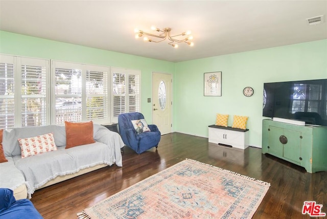 living room with an inviting chandelier and dark wood-type flooring