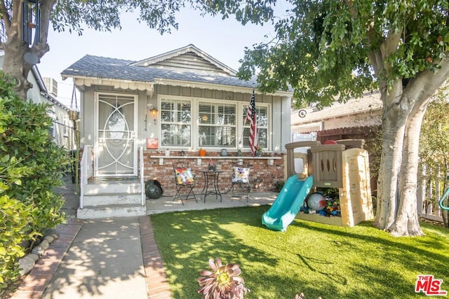 view of front of home featuring a playground and a front lawn