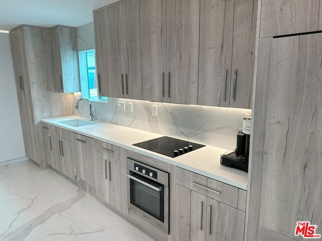 kitchen with black electric stovetop, sink, stainless steel oven, and light brown cabinets