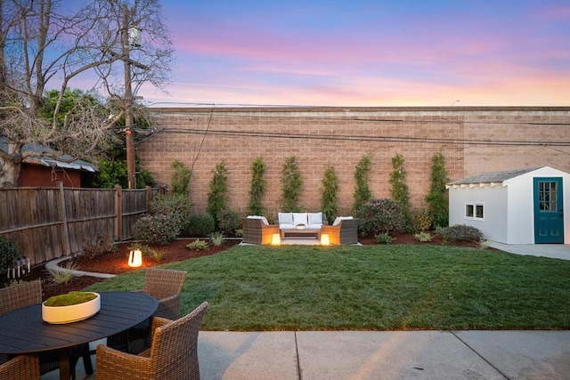 yard at dusk with a storage unit and an outdoor living space