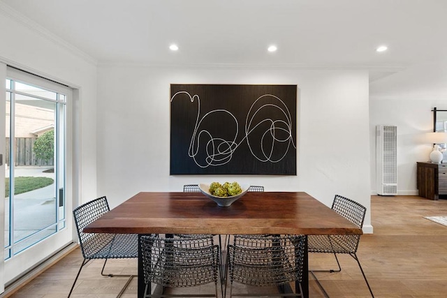 dining space featuring crown molding and light hardwood / wood-style flooring