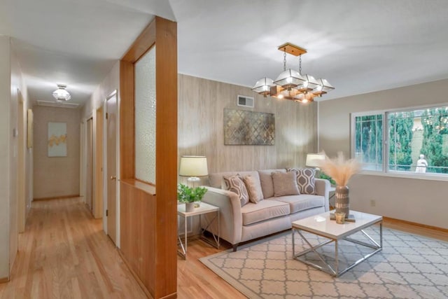 living room with light hardwood / wood-style flooring and a chandelier