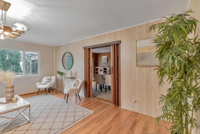 sitting room featuring wood-type flooring and wooden walls