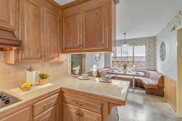 kitchen with black electric cooktop, tasteful backsplash, tile counters, and hanging light fixtures