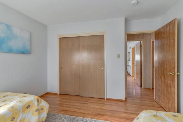 bedroom with light hardwood / wood-style flooring and a closet